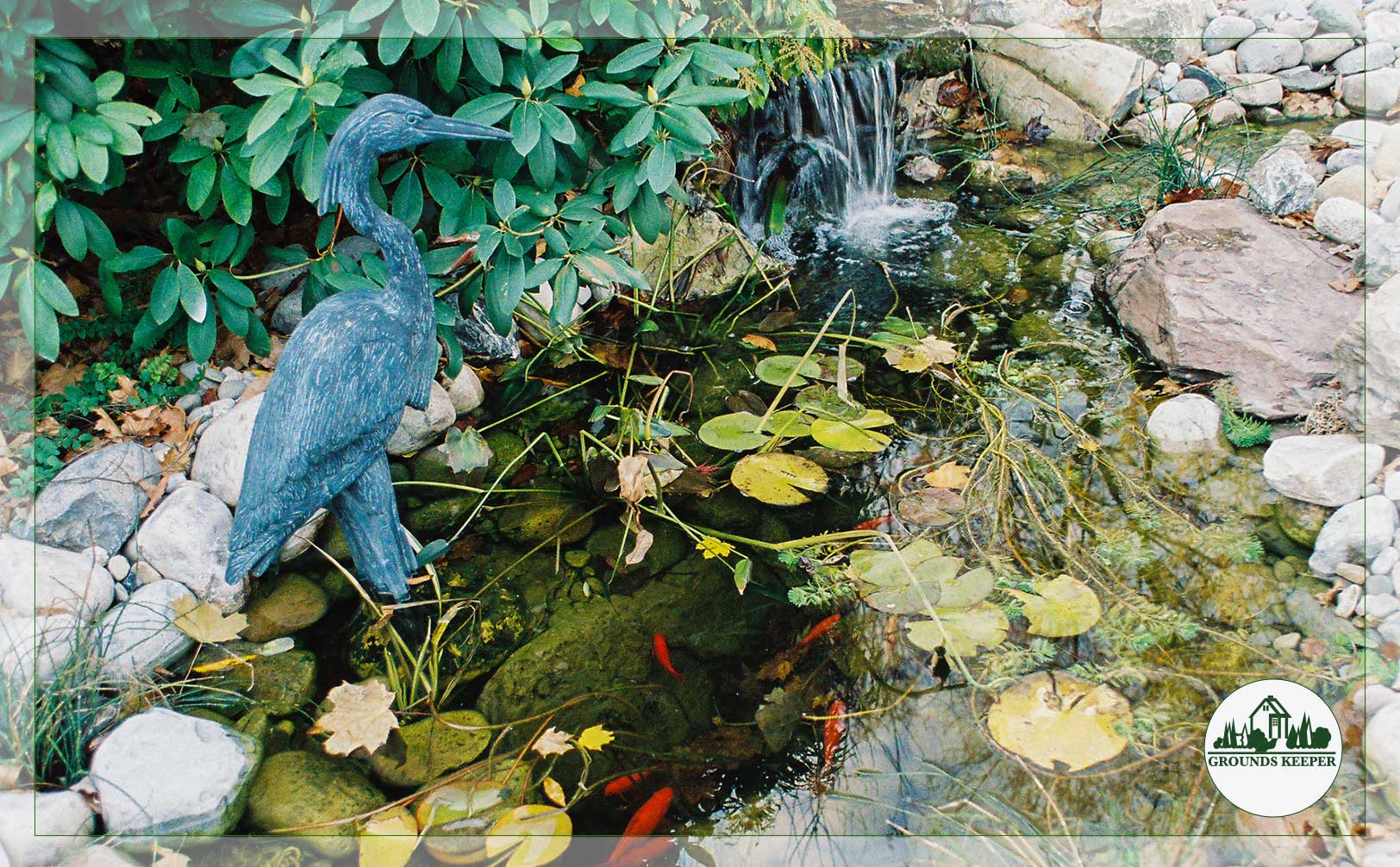 small pond with waterfall and heron statue
