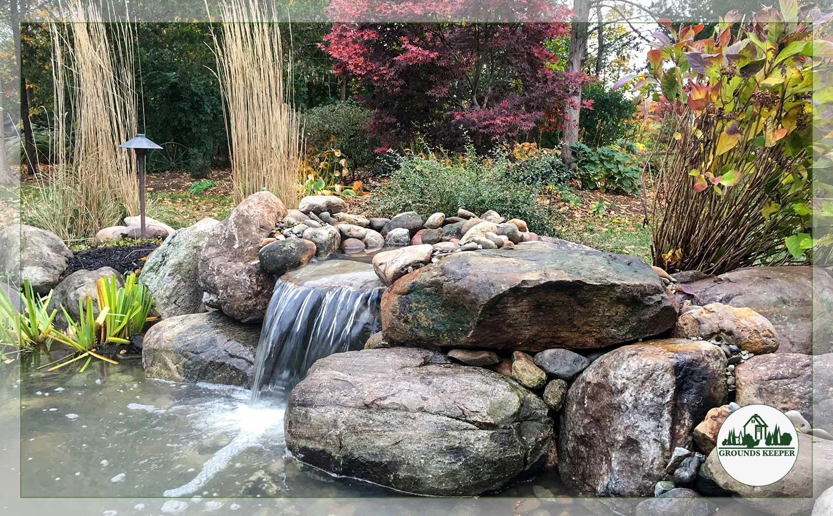 pond and waterfall surrounded by fall color 