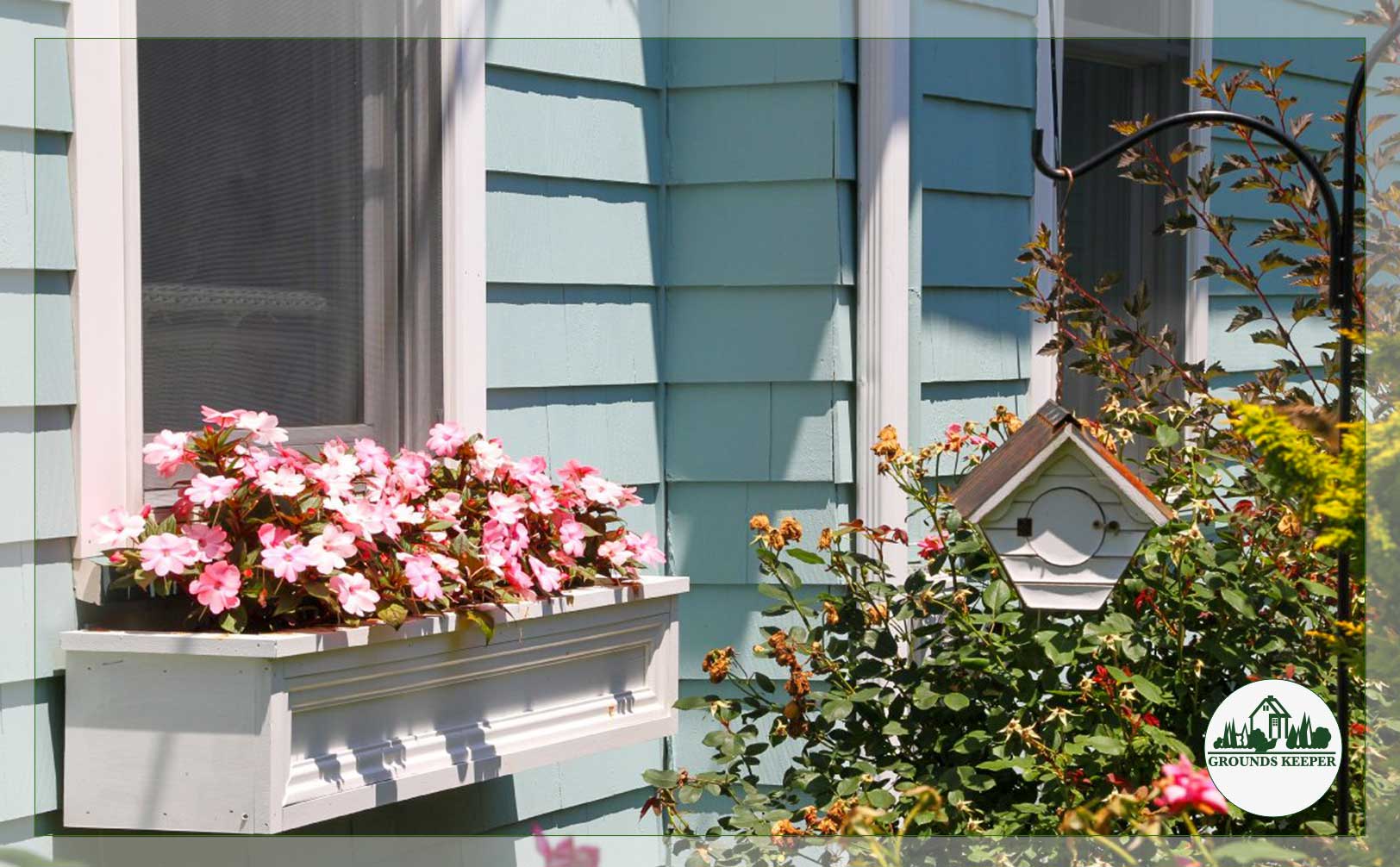 blue house with pink window box flowers and birdhouse