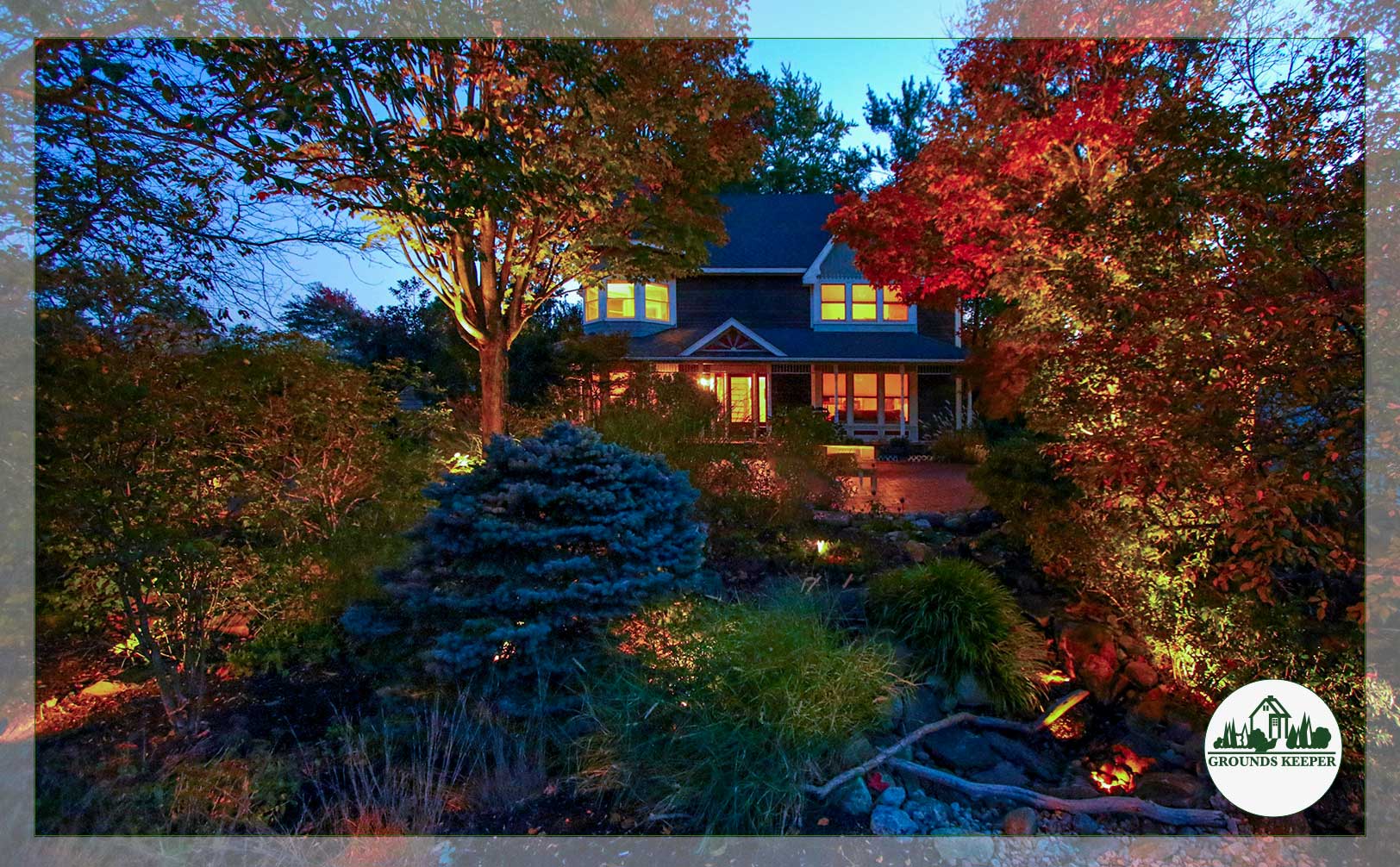 home lit up on an autumn evening with colorful surrounding trees