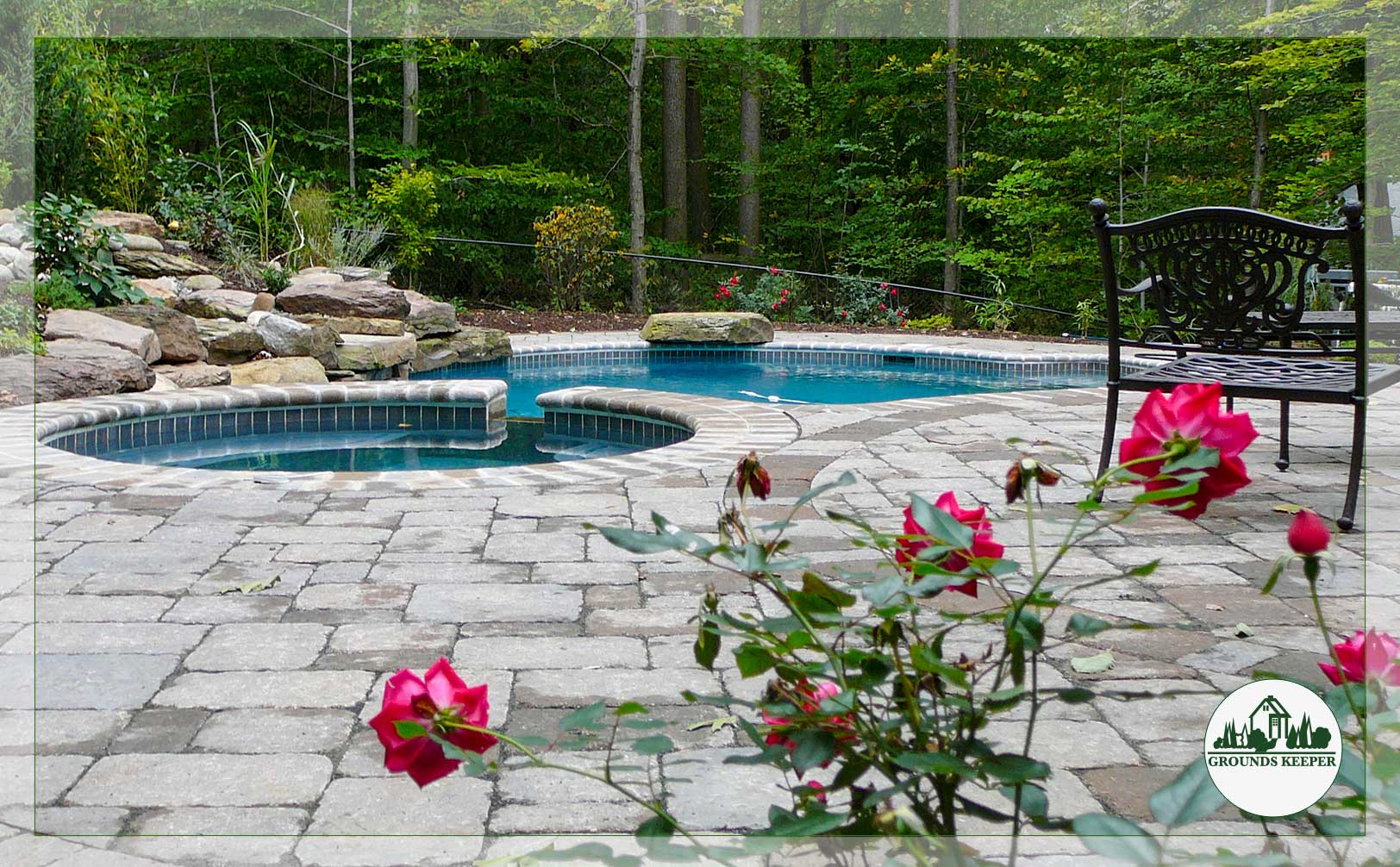 pool and patio with wrought iron bench and roses