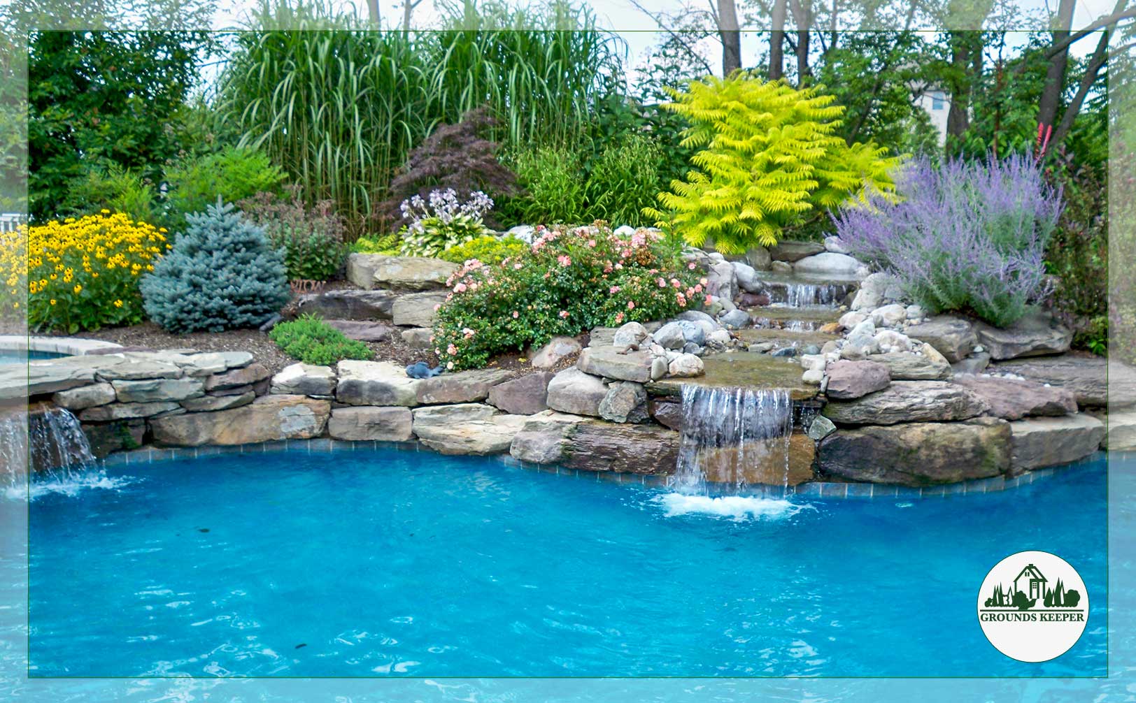 pool with waterfall, stone and landscaped backdrop