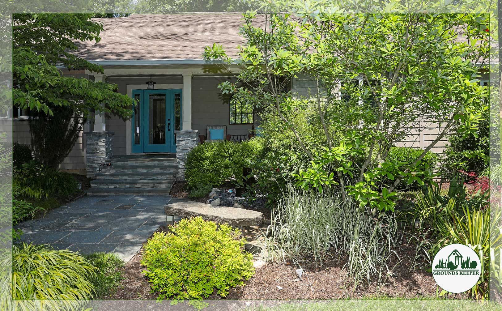 house with blue door and front yard stone bench
