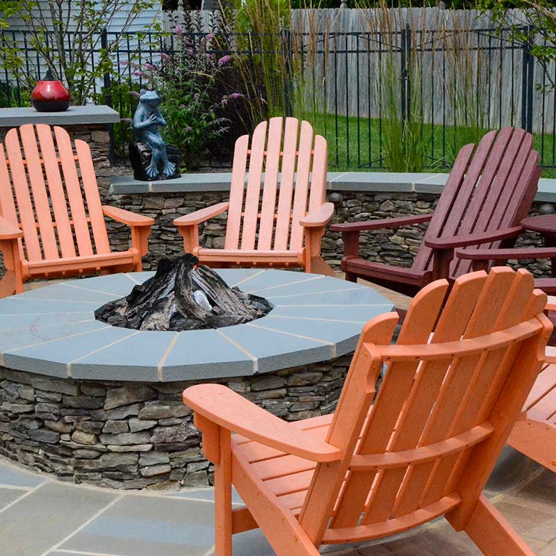 fire pit with adirondack chairs and frog sculpture