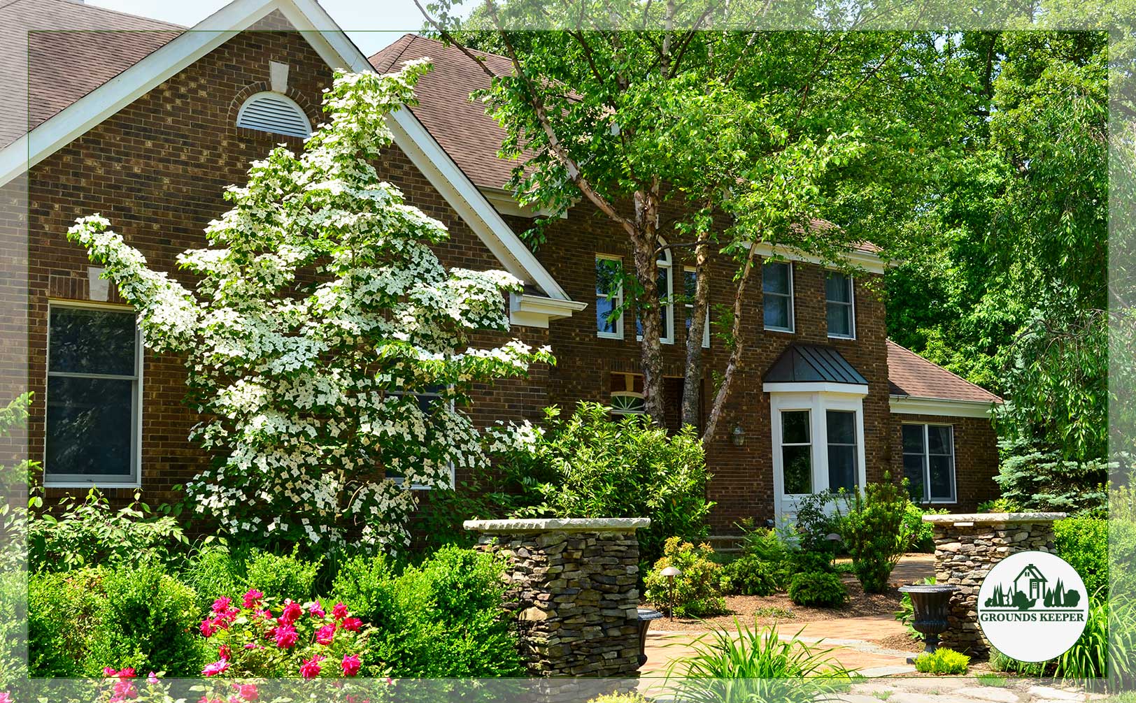 curb appeal with natural stone flowers and blossoming tree 