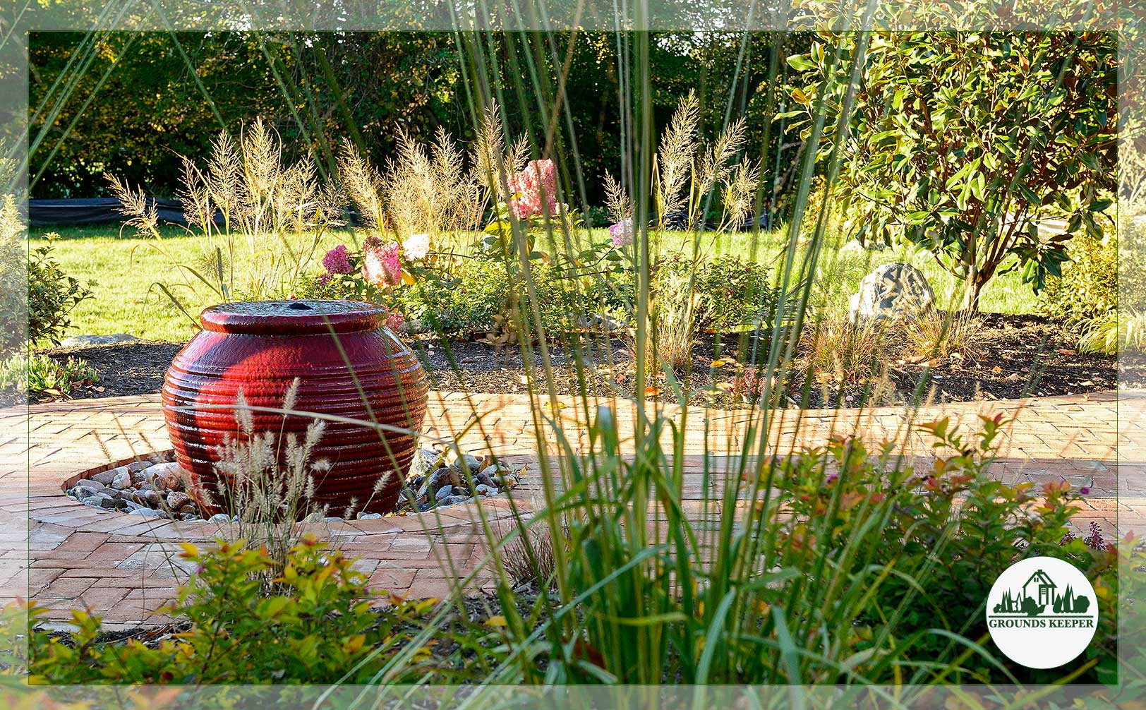 red bubbling water feature with tall grasses