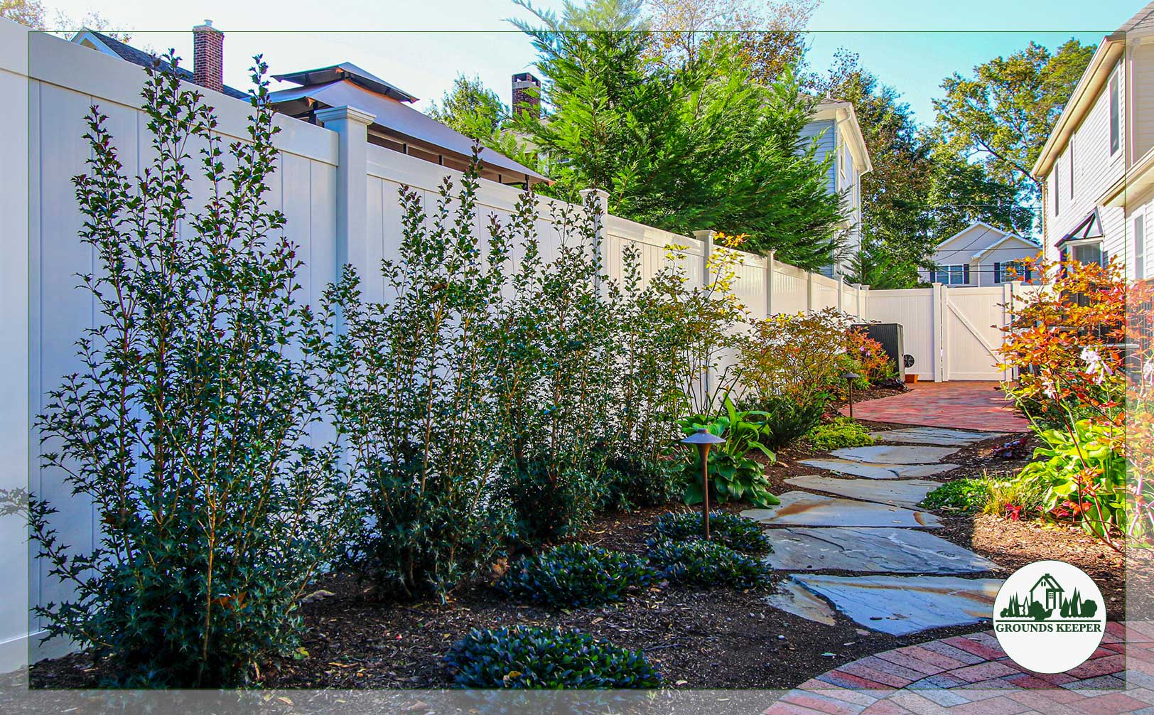 side yard fence and landscaping with stone path